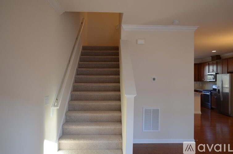 A staircase with a carpeted runner and a wooden handrail.