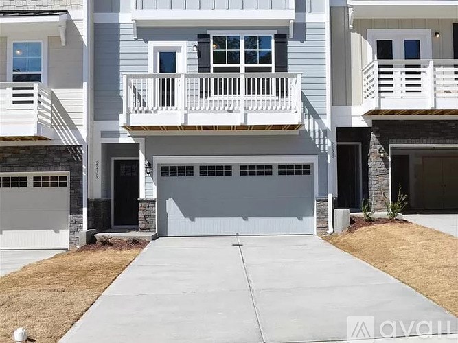 A modern two-story house with a balcony and a garage.