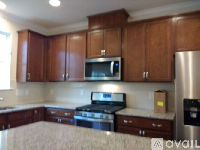 A kitchen with wooden cabinets and a stainless steel refrigerator.