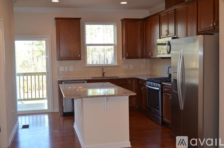 A kitchen with a white island and stainless steel appliances.