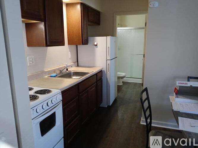 A kitchen with white appliances and dark wood cabinets.