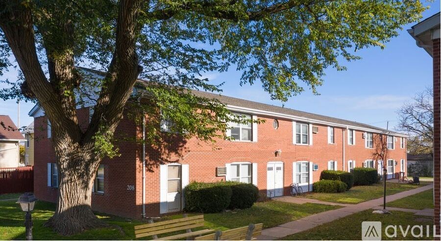 A row of red brick houses with green trees in front.