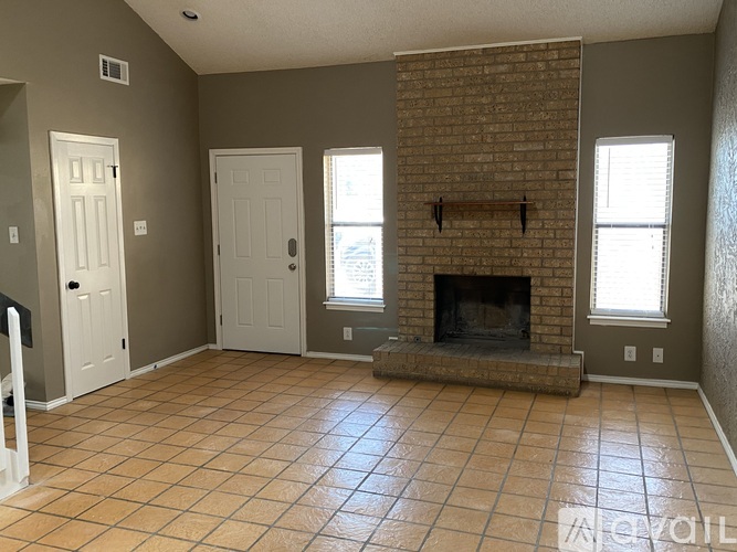 A living room with a fireplace and tile flooring.