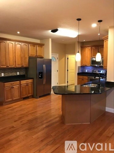 A kitchen with wooden cabinets and a black countertop.