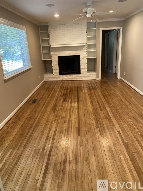 A room with a fireplace and wooden floors.