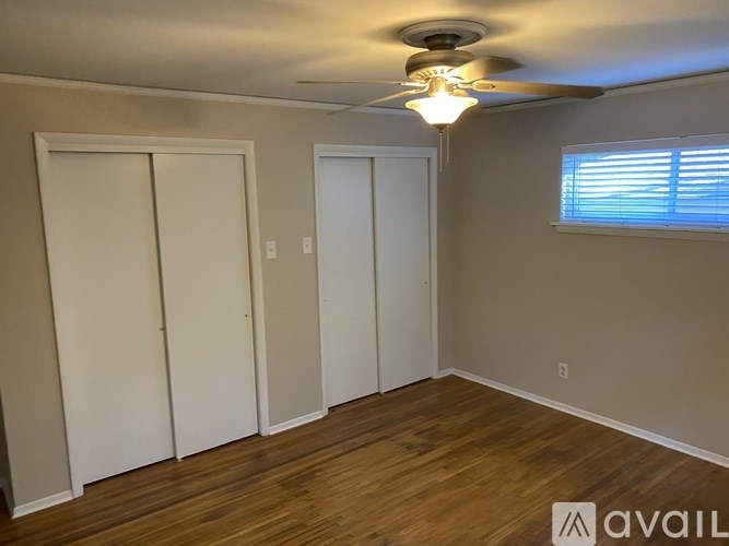 A room with a ceiling fan and two doors.