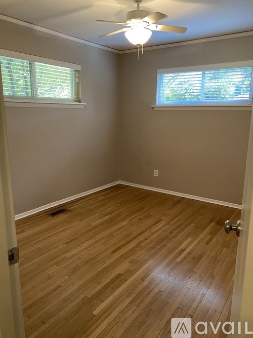 A room with wooden flooring and a ceiling fan.