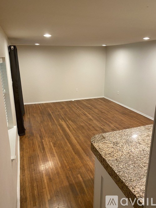A room with wooden flooring and a granite countertop.