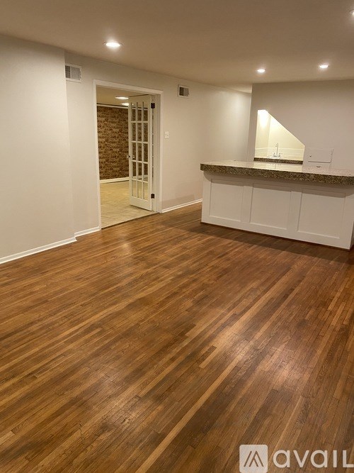 A room with wooden flooring and a white wall.