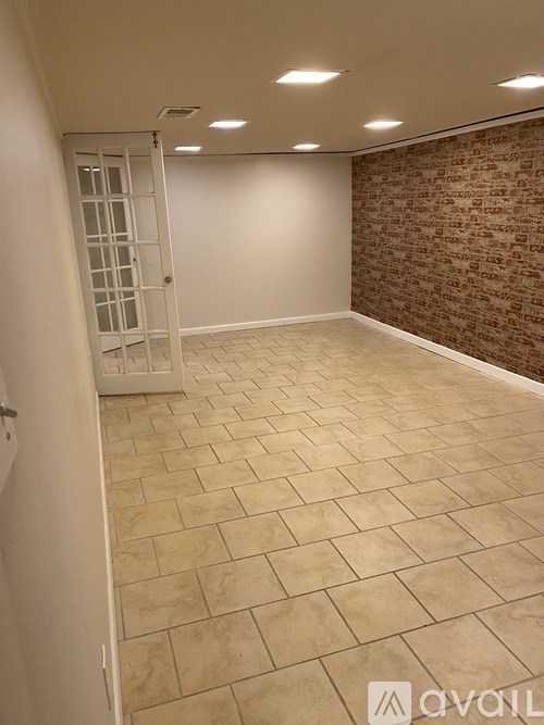 A room with a tiled floor and a brick wall.