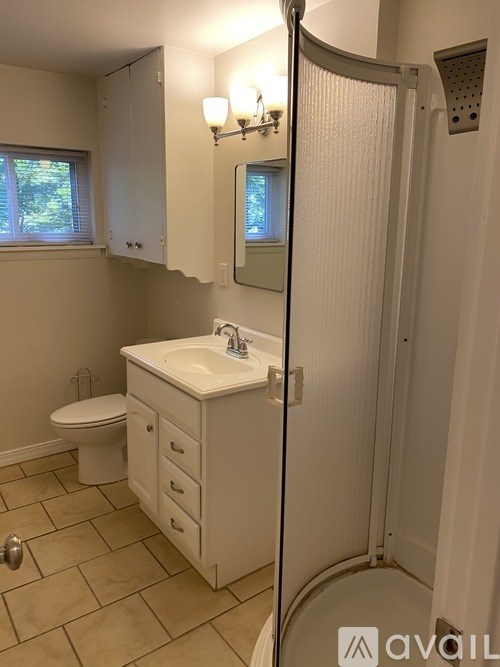A bathroom with a white sink and a white toilet.