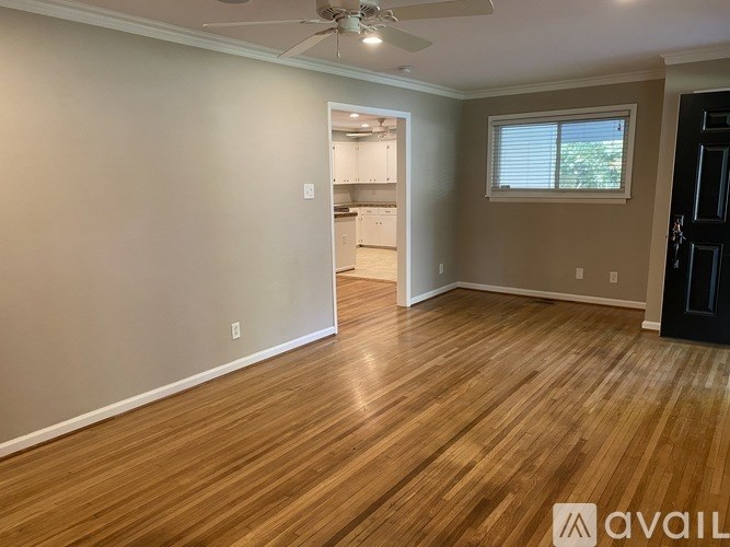 A room with wooden flooring and a ceiling fan.