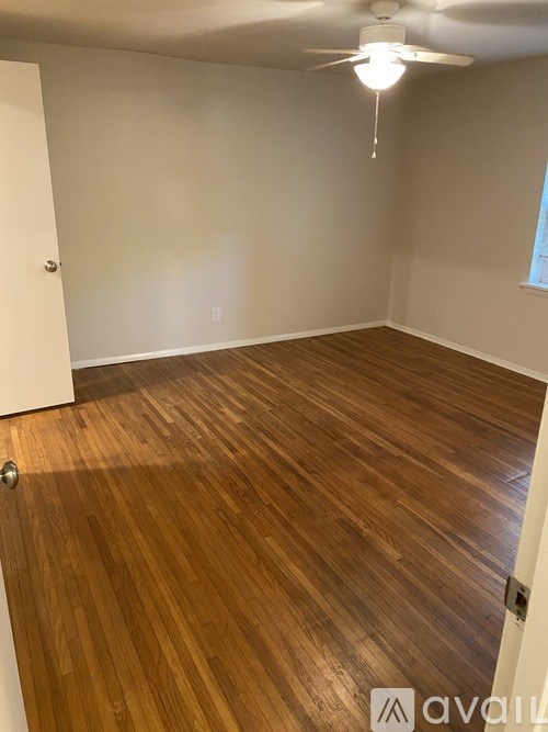 A room with wooden flooring and a ceiling fan.
