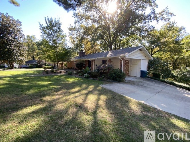 A house with a driveway and trees in the background.