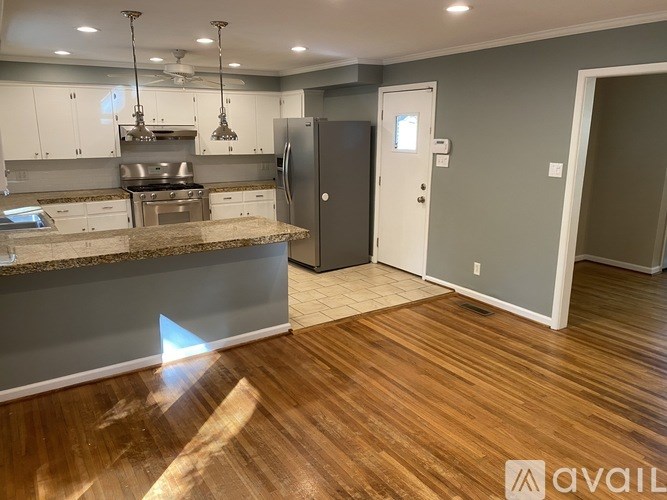 A kitchen with a refrigerator, cabinets, and a countertop.