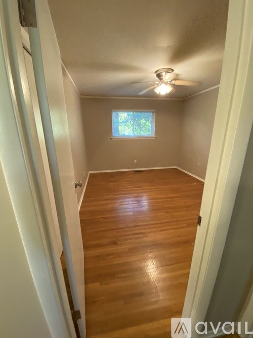 A room with wooden flooring and a ceiling fan.