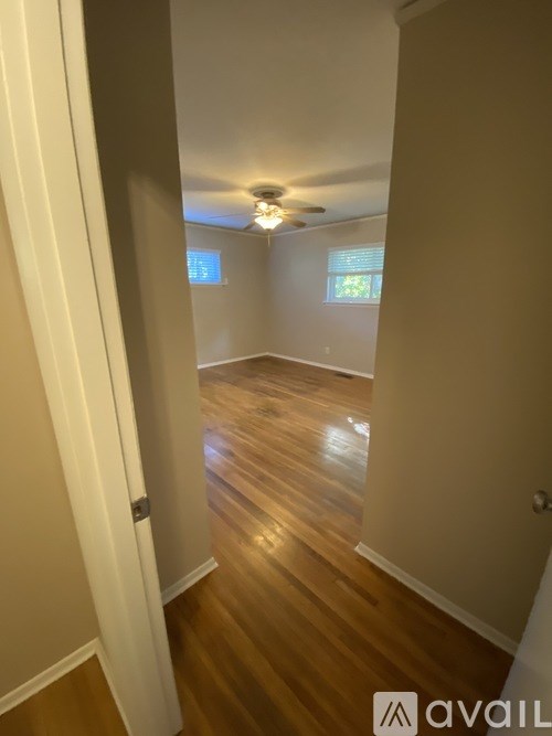 A hallway with wooden floors and white walls.