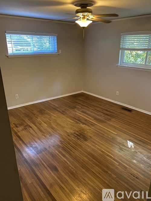 A room with wooden flooring and a ceiling fan.