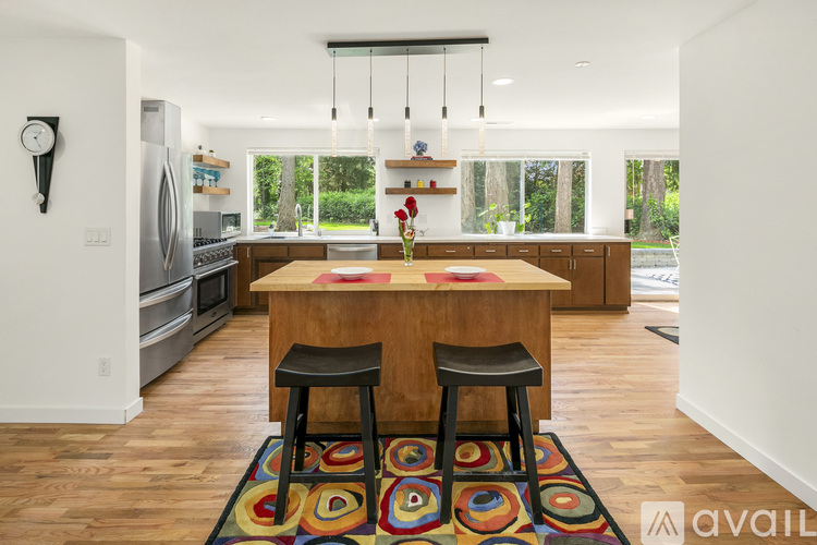 A kitchen with a wooden table and two black stools.