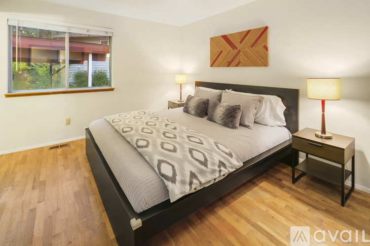 A bedroom with a large bed and a wooden floor.