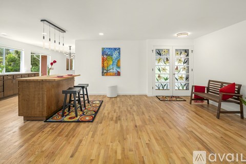 A living room with wooden floors and a large painting on the wall.