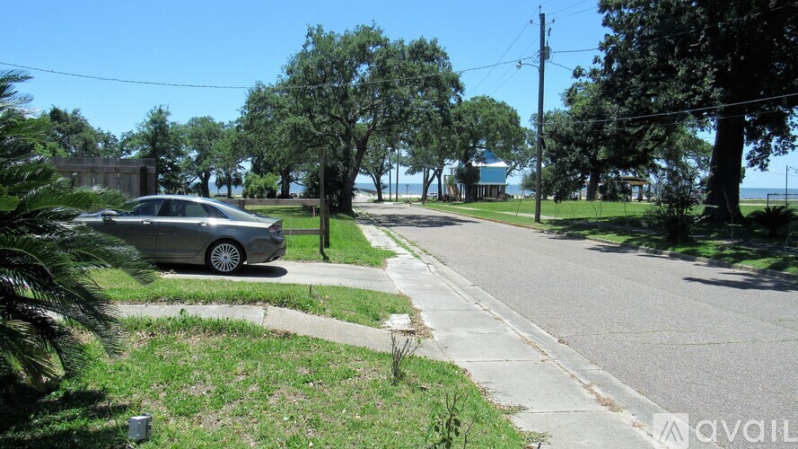 A silver car is parked on the side of a street.