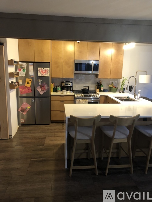 A kitchen with a refrigerator, stove, and sink.