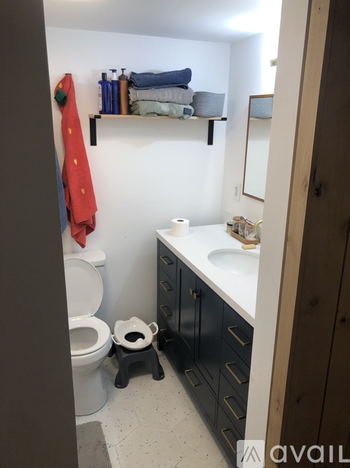 A bathroom with a toilet, sink, and towels.