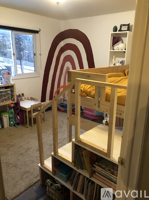 A room with a bed, a desk, and a shelf.