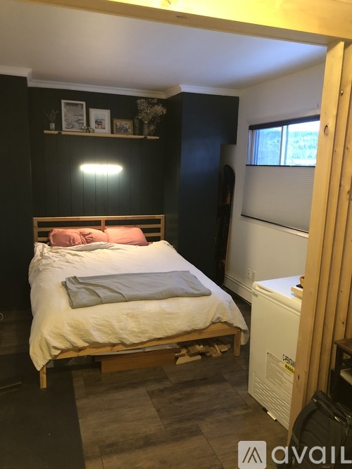 A bedroom with a bed, nightstand, and window.