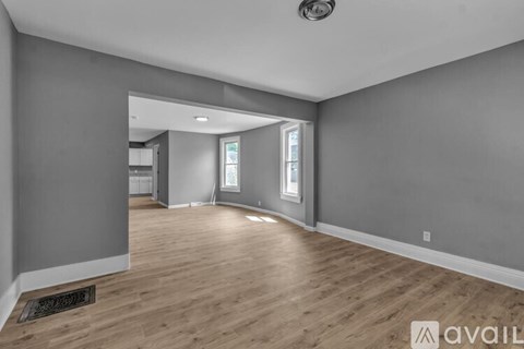 A spacious room with wooden flooring and a ceiling light.