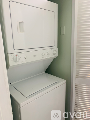 A white oven with a control panel on the front and a white wall behind it.