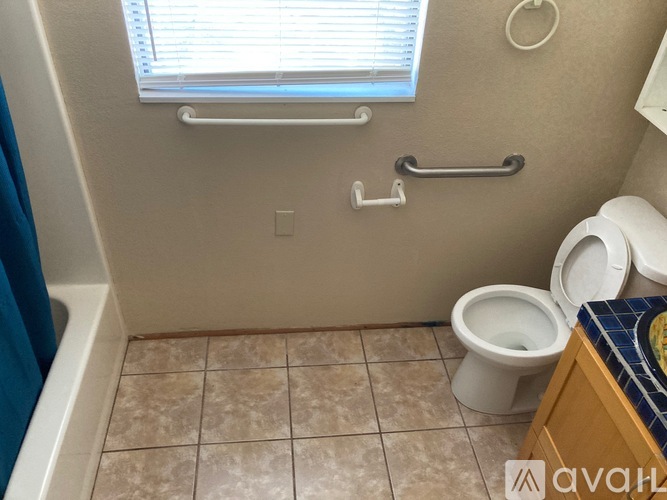 A bathroom with a toilet, a towel rack, and a window.