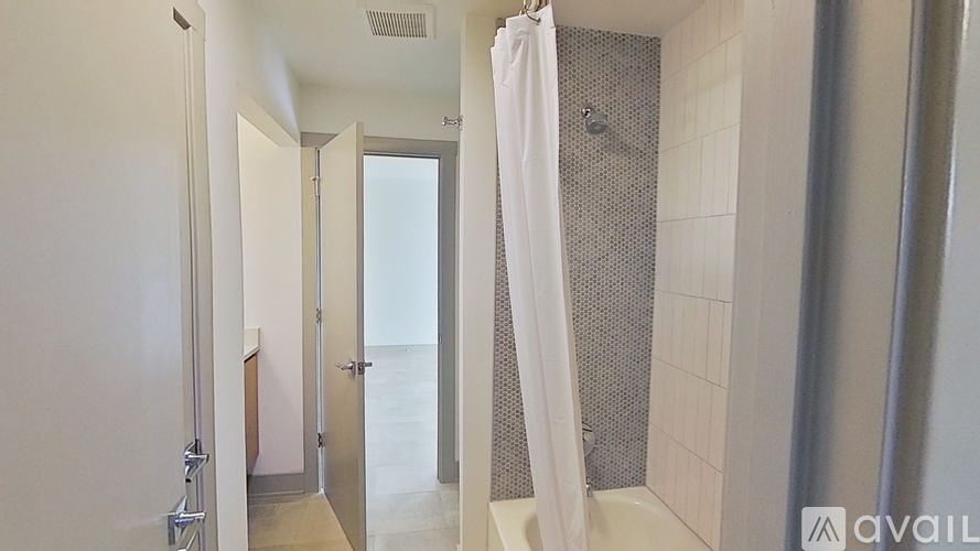 A bathroom with a shower curtain and a glass door.