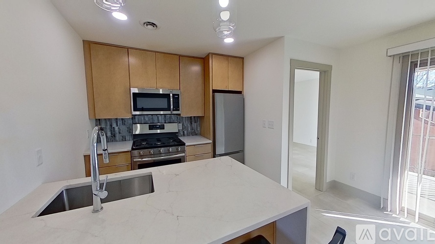 A kitchen with a sink, stove, and microwave.