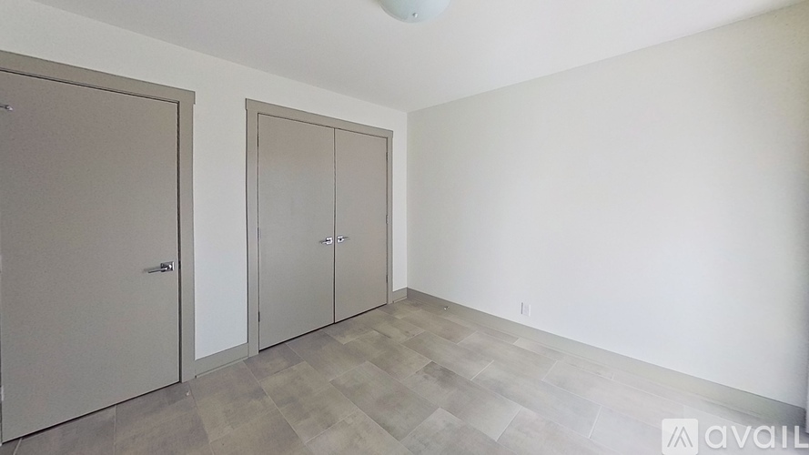 A room with three doors and a wooden floor.