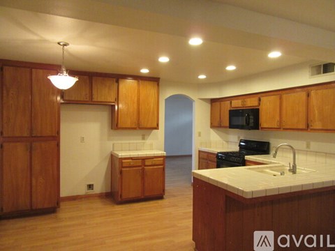 A kitchen with wooden cabinets and a white countertop.
