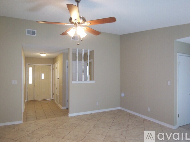 A room with a ceiling fan and tiled flooring.