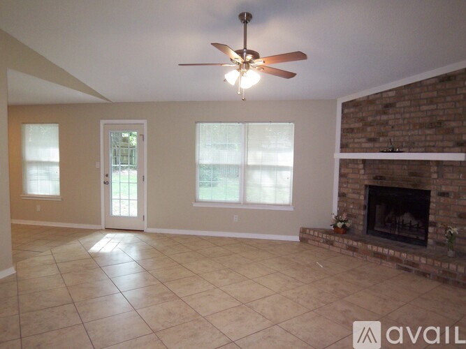 A living room with a fireplace and a ceiling fan.
