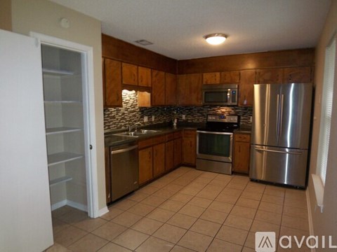 A kitchen with a refrigerator, sink, and microwave.