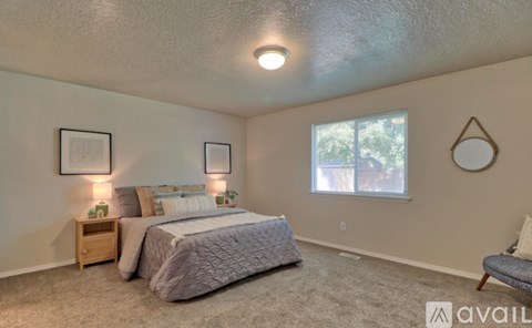 A bedroom with two beds and a nightstand with a lamp.