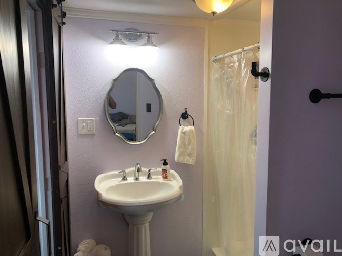 A bathroom with a sink, mirror, and towel rack.