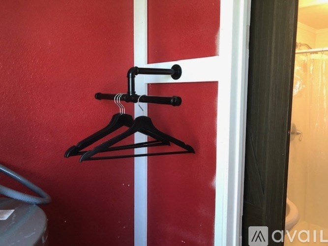 A black hanger is hanging on a white door.