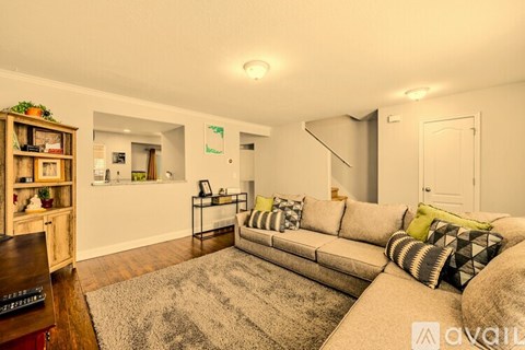 A living room with a grey sofa and a wooden bookshelf.