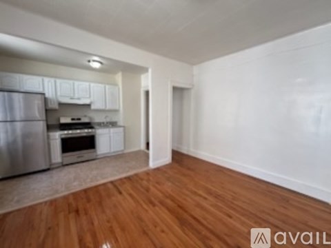 A kitchen with white cabinets and a stainless steel refrigerator.