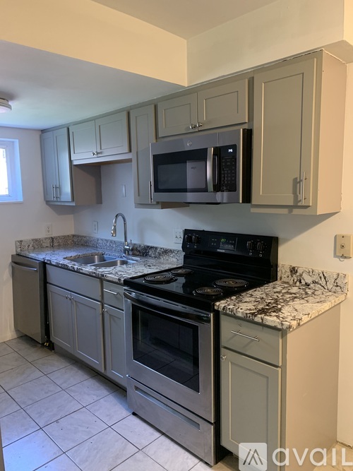 A kitchen with a granite countertop and stainless steel appliances.