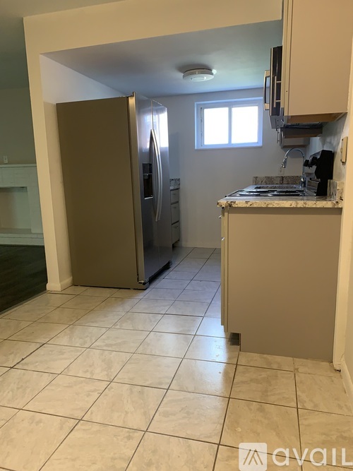 A kitchen with a refrigerator, stove, and cabinets.