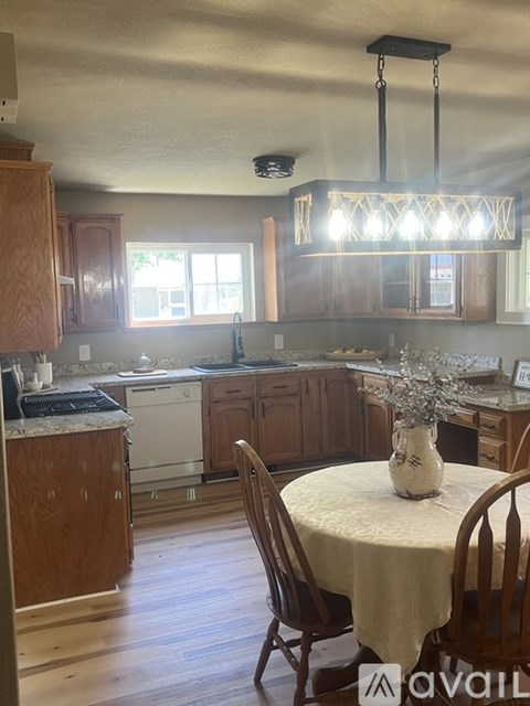 A kitchen with wooden cabinets and a table with chairs.