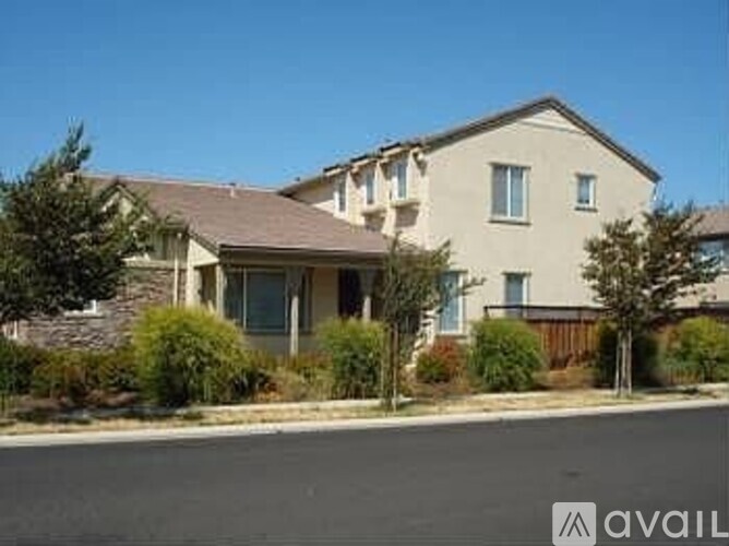 A house with a brown roof and a white wall is available for sale.