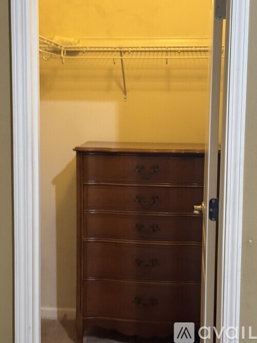 A brown chest of drawers is in a room.